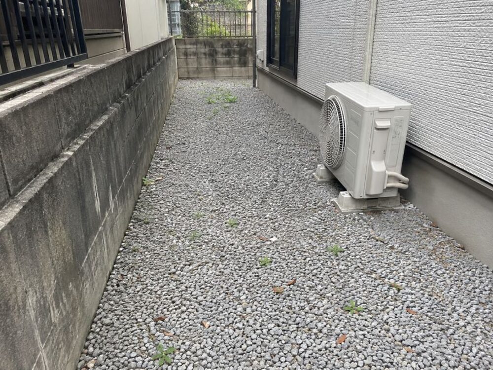 空き家管理レポートの作業前の写真：建物脇 砂利通路