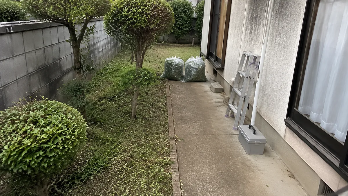 草刈りと庭木の手入れを終えた庭。刈った草は袋にまとめてある